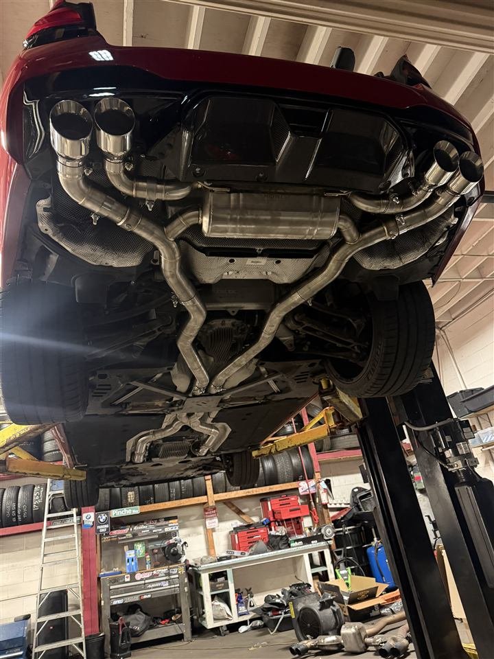 Aftermarket exhaust under a car on the lift